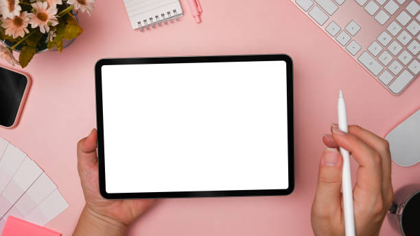 istock Top view creative woman holding stylus pen and digital tablet with empty screen. 1329807202