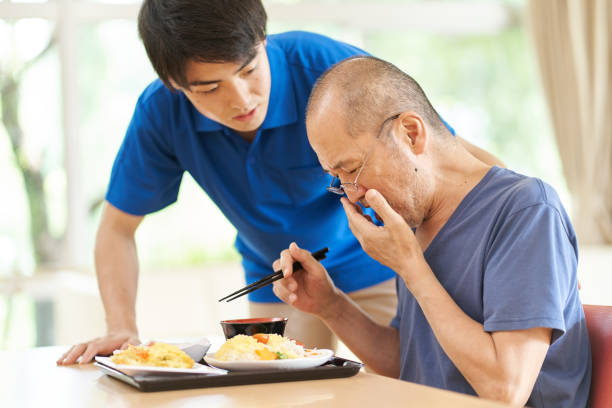 食事中に咳をする高齢者 - dysphagia ストックフォトと画像