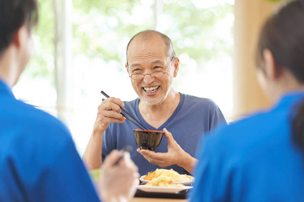 istock Elderly people having fun eating at a long-term care facility 1329807857