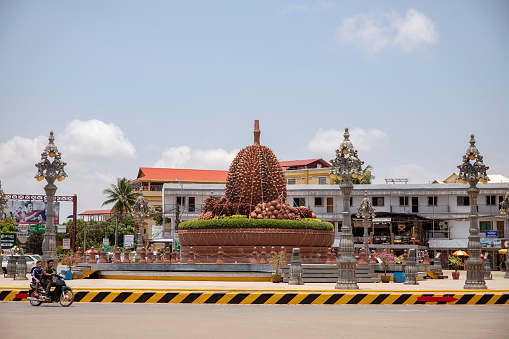 Kampot, Cambodia - 12 April 2018: town view with durian monument on city square. Cambodian travel photo. Tourist place sightseeing. Khmer daily routine. Urban landscape with colonial architecture