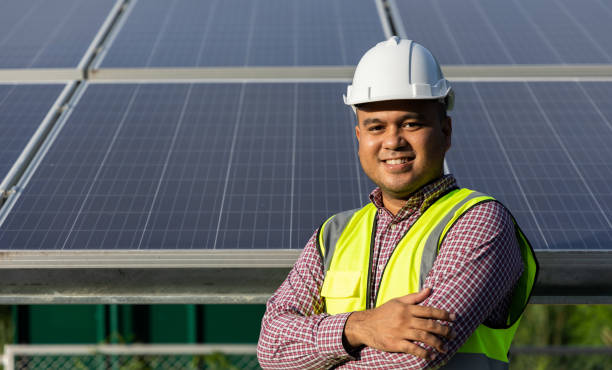 istock Young asian electrical engineer standing in front of Solar cell panels farm. He checking and installing. Solar generator power concept. 1329812435