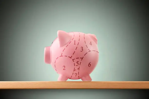 Piggy bank divided into seven parts with a dashed line.
