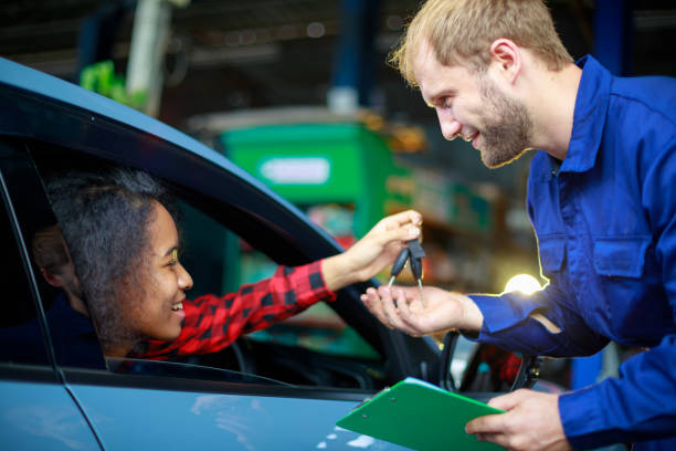 istock A female customer get car key from mechanic engineer. 1329813829