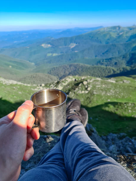 istock point of view. holding mug with coffee looking at mountains 1329814694