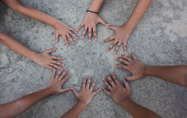 istock Multicultural hands man woman children in circle on street sidewalk. Support helping teamwork togetherness international diversity race ethnicity education and people concept banner, vintage old style 1329815481