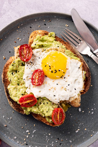 istock Avocado Toast with a Fried Egg, Oven Dried Tomatoes and Toasted Sesame Seeds. 1329818732