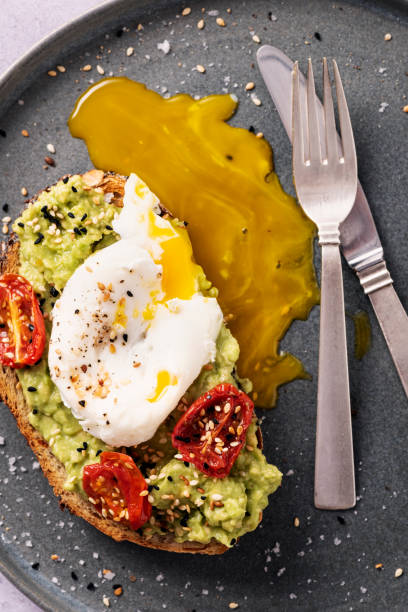 istock Avocado Toast with Eggs Benedict, Oven Dried Tomatoes and Toasted Sesame Seeds. 1329818808