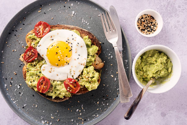 istock Avocado Toast with a Fried Egg, Oven Dried Tomatoes and Toasted Sesame Seeds. 1329818863
