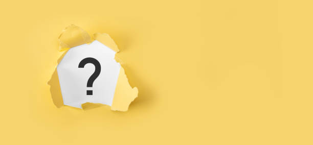Question mark concept. Torn yellow paper with question mark on white background.