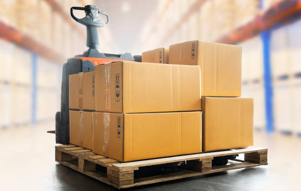 istock Package Boxes on Pallet with Electric Forklift pallet Jack Load at The Storage Warehouse. Storehouse, Shipping Warehouse Logistics. 1329822709