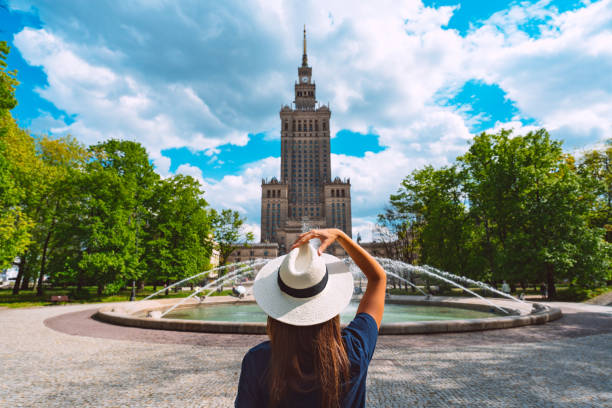 Young tourist woman in white sun hat walking in the park near Palace of Culture and Science in Warsaw city, Poland. Summer vacation in Warsaw Young tourist woman in white sun hat walking in the park near Palace of Culture and Science in Warsaw city, Poland. Summer vacation in Warsaw. High quality photo warsaw stock pictures, royalty-free photos & images