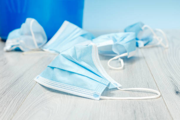 istock Used medical protective masks on a floor. 1329826181