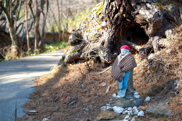 les petites statues japonaises connues sous le nom de jizo ou le bonnet honorifique portent un bonnet redknit le long du sentier dans la source chaude du parc sainokawara à kusatsu onsen, au japon. - shintoïsme photos et images de collection