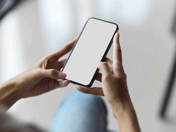 istock Top view of female hands using mobile phone with blank screen 1329831611