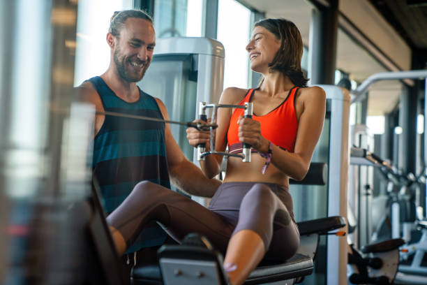 istock Personal trainer helping woman working out in gym 1329832995
