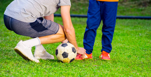 istock Coach tying shoe lace of boy 1329835501