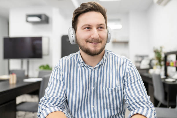 istock man with headphones in office working happy smiling 1329835886