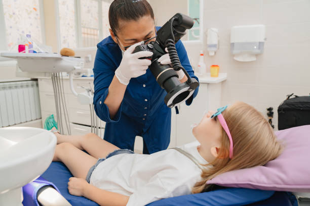 photo protocol in dentistry.the doctor photographs the teeth of the girl's child photo protocol in dentistry.the doctor photographs the teeth of the girl's child, examines the mouth of a kid girl. regular visits to the doctor's office. treatment and prevention of caries. dental health photos stock pictures, royalty-free photos & images