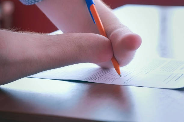 istock Disabled man with two amputated stump hands signs documents makes paper work. 1329836973