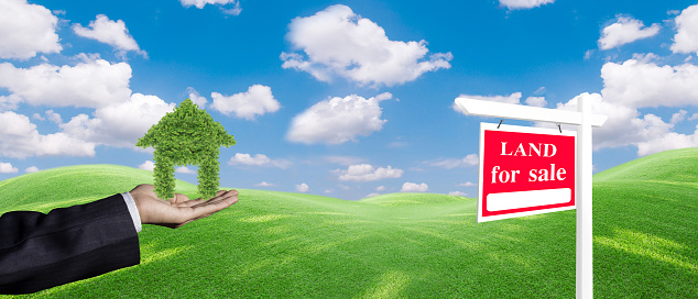Panorama house symbol and land For Sale signboard on the meadow under clear sky in real estate sale or property investment concept, Buying new home for family.