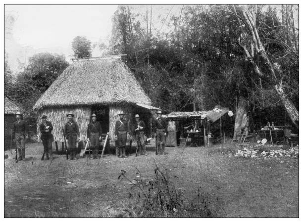 Antique black and white photograph: American soldiers in village, Philippines Antique black and white photograph of people from islands in the Caribbean and in the Pacific Ocean; Cuba, Hawaii, Philippines and others: American soldiers in village, Philippines filipino ethnicity stock illustrations