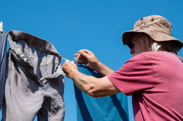 istock Retired man hanging out a clothes on a clothes line 1329841858