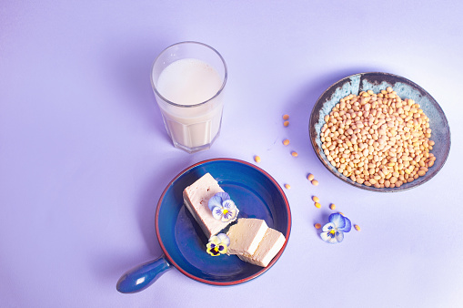 Tofu soy beans and soy milk dairy substitute vegan vegetarian minimalistic copy space negative space pastel purple background food style inspiration