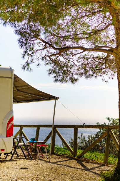 istock Camper and chairs on sea shore 1329844205