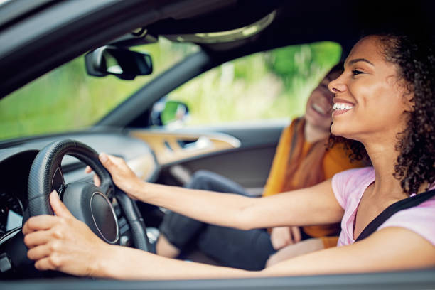 istock Girlfriends driving a car and having fun 1329845498