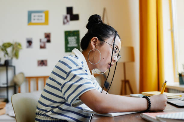 istock Teenage Girl Doing Homework Side View 1329845501