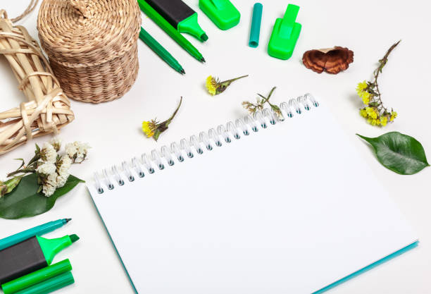 istock Blank page of spiral notepad on white table. Crayon pencil and pen flat lay photo. Empty sketchbook page on table top view. 1329847209