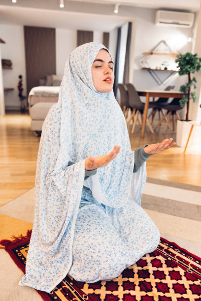 istock Middle Eastern Woman Praying at her Apartment 1329847311