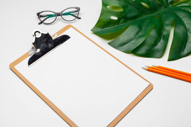 istock Home office workspace mockup with clipboard, palm leaf and accessories. Flat lay, top view 1329850115