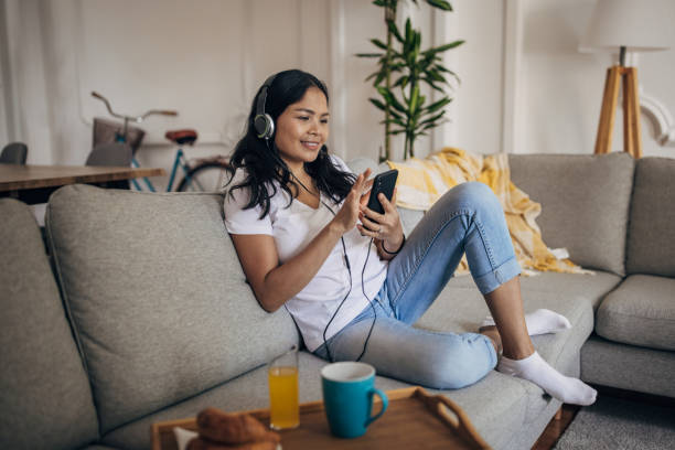 istock Woman sitting on sofa at home 1329850280