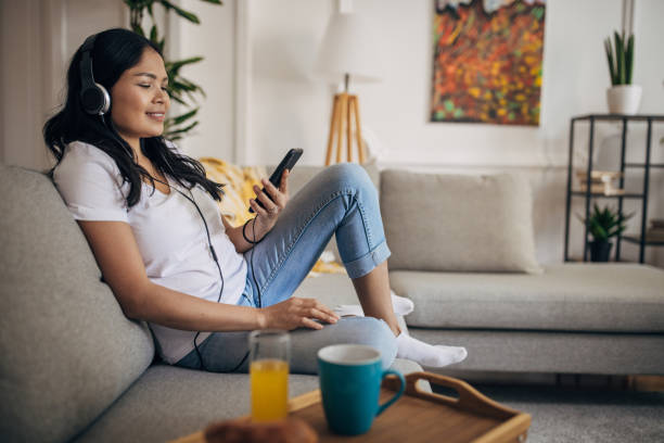 istock Woman sitting on sofa at home 1329850888