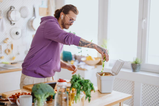 istock Man putting organic waste in compost bin 1329850898