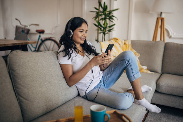 istock Woman sitting on sofa at home 1329850917