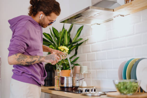 istock Young man cooking at home 1329851034
