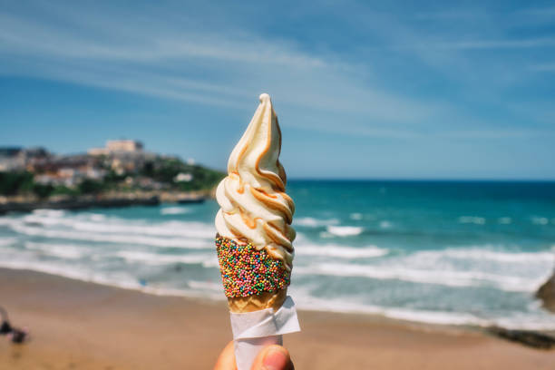 istock Ice Cream cone with caramel sauce at Towan Beach, Newquay, Cornwall on a sunny summers day. 1329851272