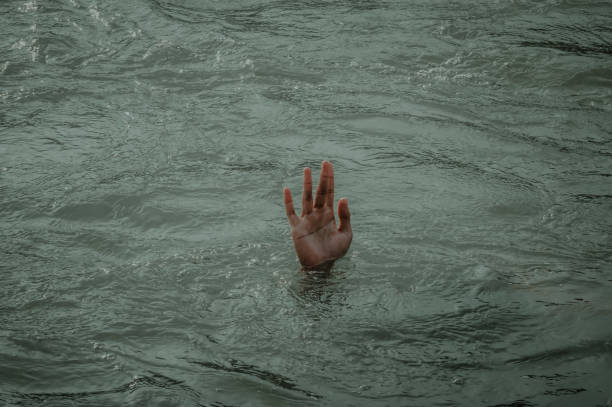 istock Illustration of drowning human hand emerging from the water 1329851678