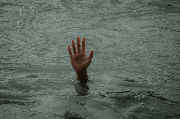 istock Illustration of drowning human hand emerging from the water 1329851705
