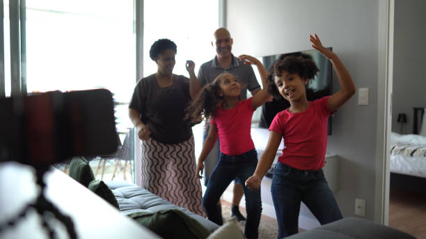 Family dancing, filming and sharing it on social media at home