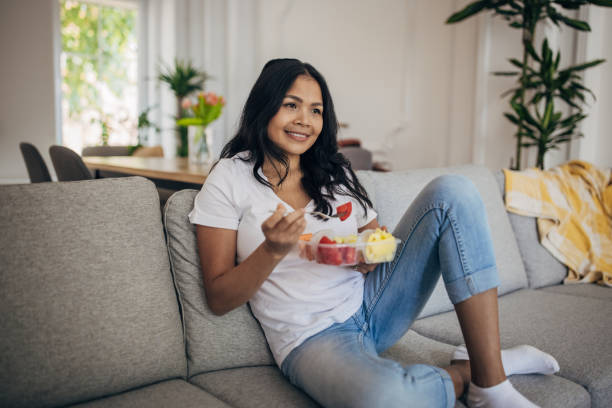 istock Woman eating salad at home 1329852526