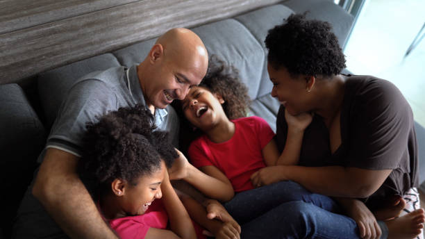 istock Parents tickling daughters at home 1329852554