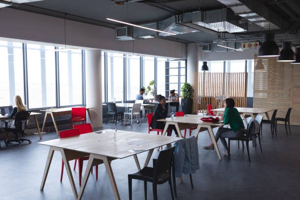 istock Diverse group of creative colleagues sitting at desks working and talking 1329854339