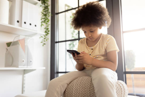 istock Little girl using smart phone while waiting for the doctor at his office 1329854569