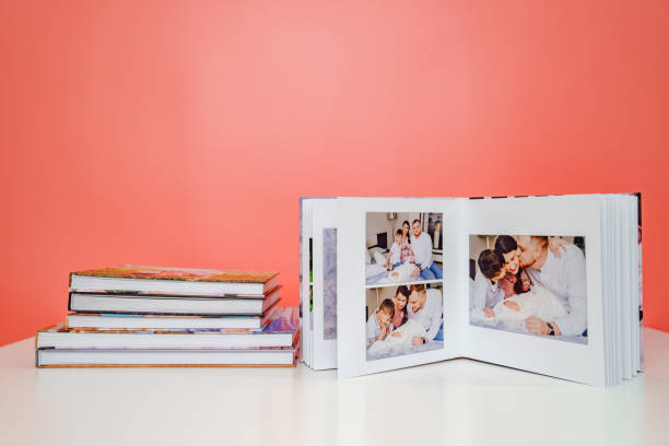 su fotolibri di sfondo rosa. album aperto da servizio fotografico di famiglia con neonato - book photo album publication open foto e immagini stock