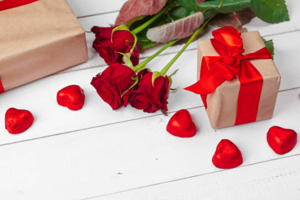 istock St. Valentines Day. Red roses and gift box on wooden table 1329859252