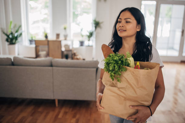 istock Woman carrying groceries bag 1329859452