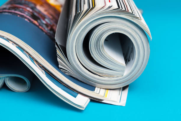 glossy magazine with pages rolled - newspaper business close up nobody imagens e fotografias de stock